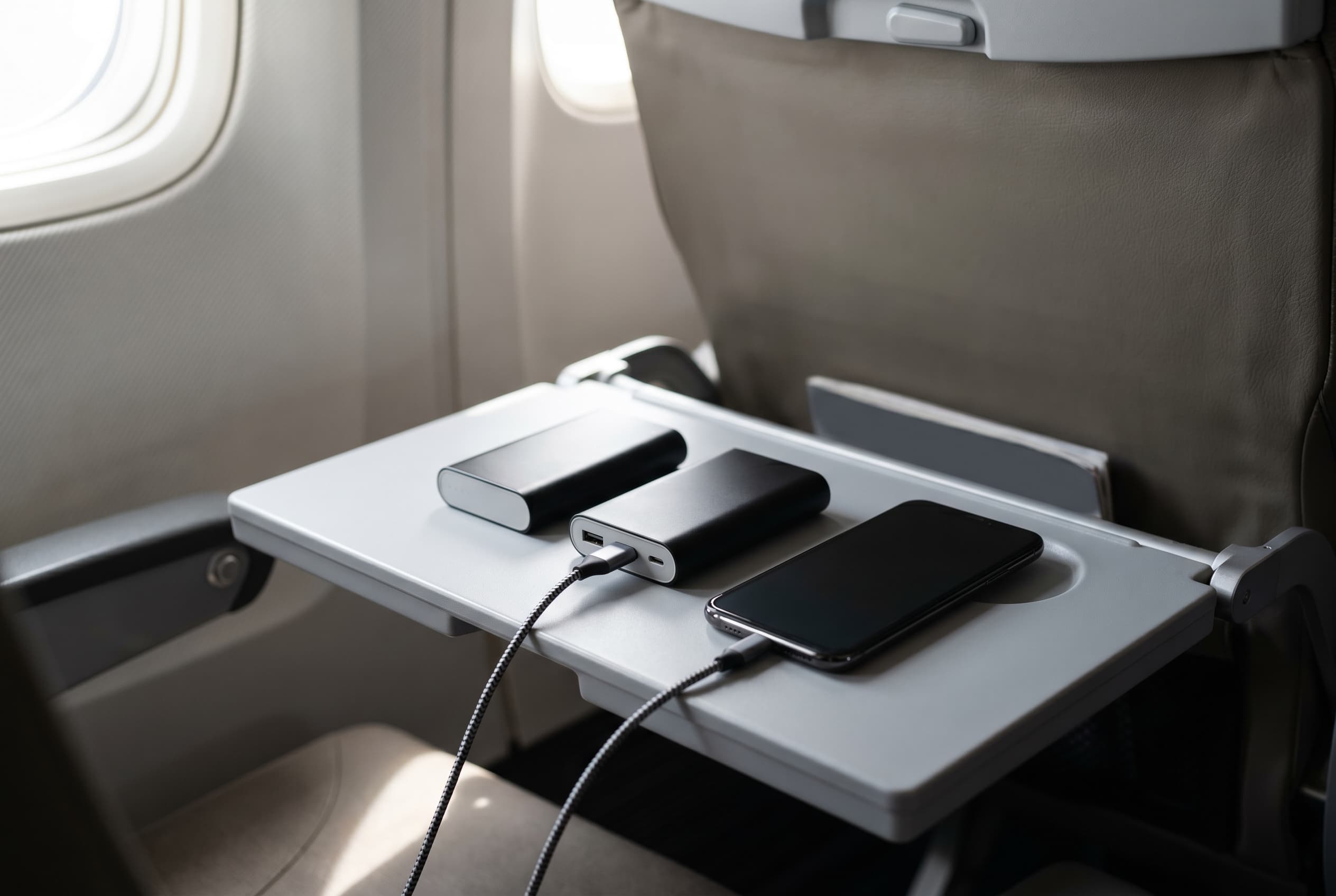 Power banks and phone on an airplane tray table